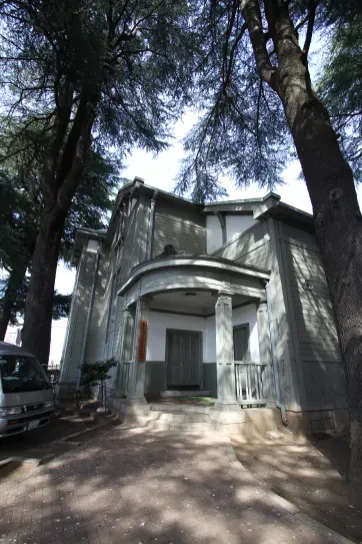 講堂の入口も隅入りでポーチはドーム屋根で簡便な古典様式を用い屋根上の換気用小塔にも意匠的工夫が なされています。