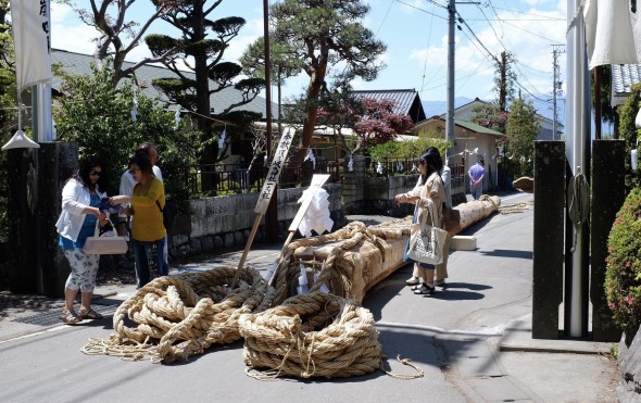 One of the Onbashira logs parked before the gate of the shrine.