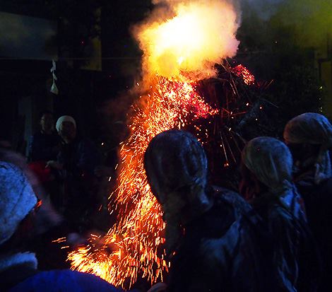 Chunks of flaming straw falling off the torch