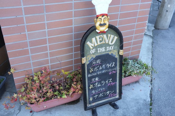 Outdoor menu with 3 recommended items for the day: Volga Rice (omurice topped with fried chicken and hayashi sauce), Omurice (rice-stuffed omelette), and Napolitan pasta