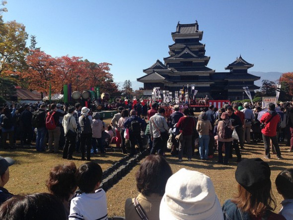 Crowd and samurai parade participants gathered at Matsumoto Castle for the official festival kick-off ceremony