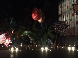 Yayoi Kusama's gigantic flower sculpture lit up in candlelight 