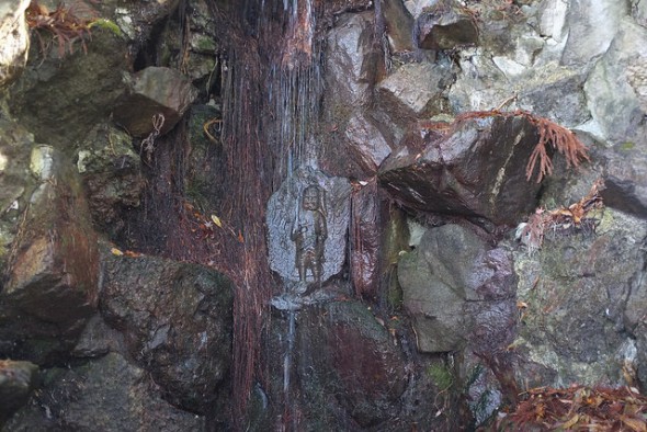A Buddhist carving behind the trickling Fudo Falls
