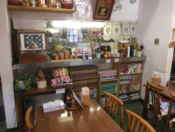The manga and trinket collection in front of the kitchen window